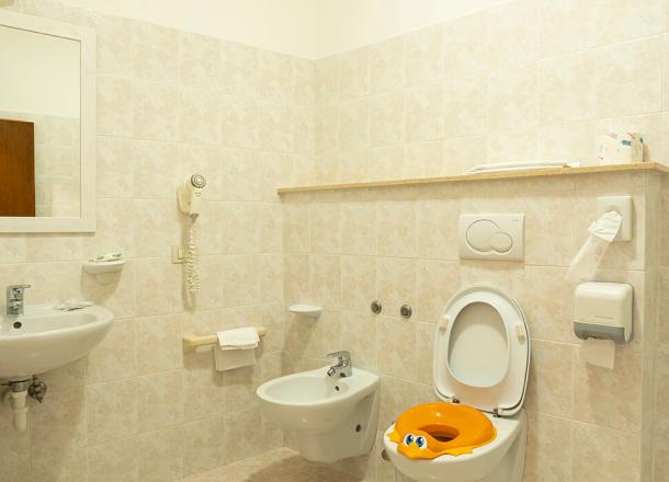 Camera con bagno dotato di vaschetta per il bagnetto all’interno del fasciatoio, scalino per il lavabo e riduttore per wc